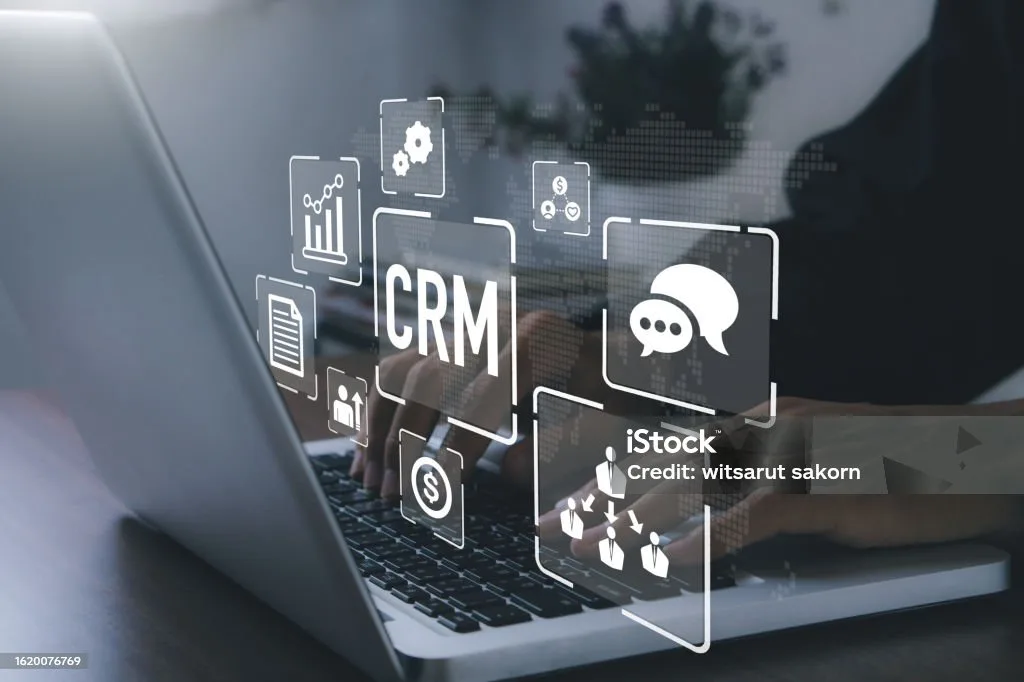 Customer relationship management CRM icons overlay a person using a laptop for business communication